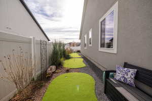 Fenced backyard with an area to practice putting