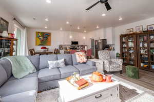 Living room featuring light wood-style flooring, recessed lighting, and ceiling fan