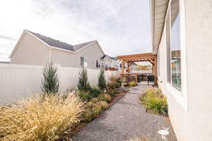 View of home's exterior with a pergola, a fenced backyard, stucco siding, and a patio