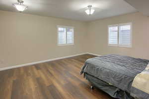 Bedroom featuring dark wood finished floors and multiple windows