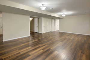Finished below grade area with dark wood finished floors and baseboards