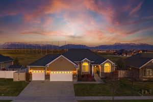 View of front facade featuring a garage, driveway, brick siding, and a mountain view
