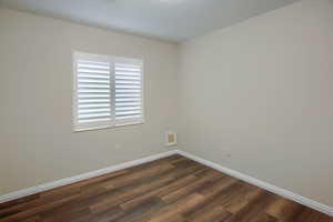 Unfurnished room featuring dark wood-style floors