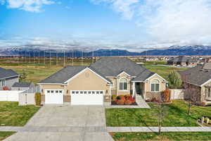 View of front of property featuring brick siding, a garage, concrete driveway, a mountain view, and a shingled roof