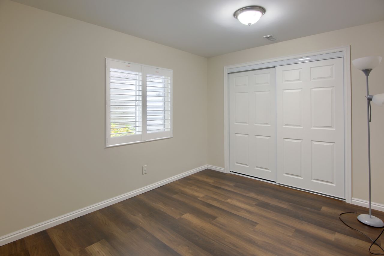 Unfurnished bedroom featuring dark wood-type flooring and a closet