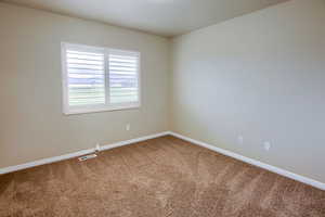 Carpeted empty room with baseboards