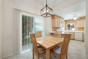 Dining space featuring light tile patterned floors, a chandelier, and ceiling fan