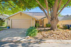 Single story home featuring stucco siding, concrete driveway, and an attached garage