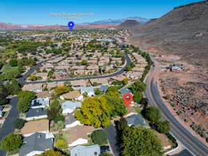 Aerial view of property and surrounding area with a mountain backdrop and nearby suburban area