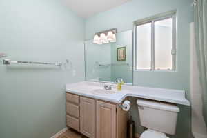 Bathroom with vanity, a shower with shower curtain, and tile patterned flooring