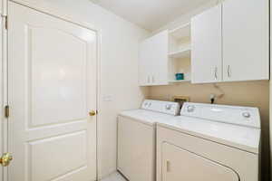 Washroom with cabinet space and washing machine and dryer