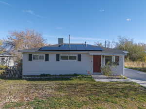 Single story home featuring roof mounted solar panels