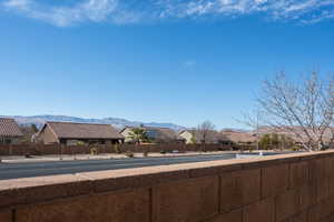 View of asphalt road featuring a mountain view and sidewalks