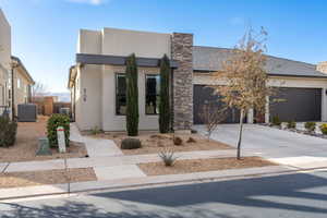 Contemporary home with driveway, stucco siding, and an attached garage