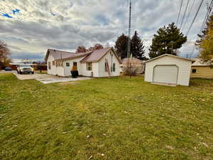 Rear view of property featuring a patio area, a metal roof, and an outbuilding