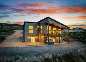 Rear view of property featuring a patio and a hot tub