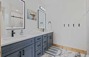 Full bath with a marble finish shower and double vanity