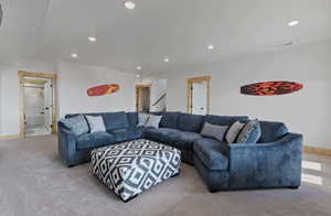 Carpeted living area with recessed lighting and baseboards