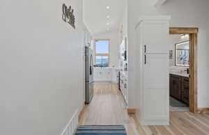 Corridor featuring recessed lighting, light wood-type flooring, and vaulted ceiling