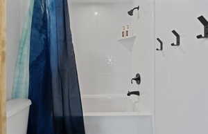 Bathroom featuring shower / bath combination with curtain and toilet