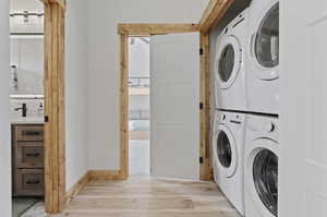 Laundry area featuring wood finished floors and washer and clothes dryer