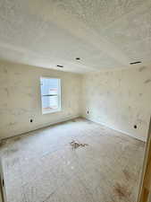 Unfurnished room featuring a textured ceiling