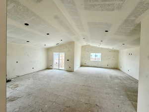Unfurnished room featuring healthy amount of natural light and lofted ceiling