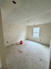 Spare room featuring a textured ceiling and baseboards