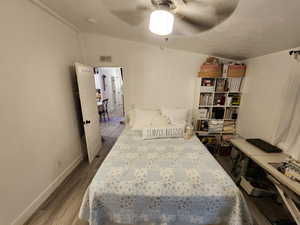Bedroom with vaulted ceiling, dark wood finished floors, and ceiling fan