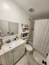 Bathroom with vanity, shower / bath combination with curtain, and light tile patterned floors