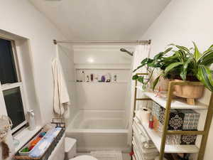 Full bath featuring a textured ceiling, shower / tub combo, and vanity