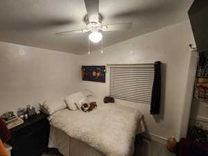 Bedroom featuring a textured ceiling, ceiling fan, and wood finished floors