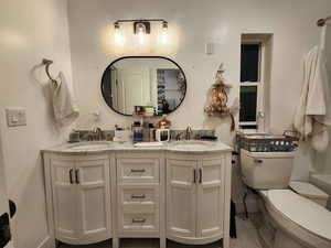 Bathroom featuring double vanity and toilet