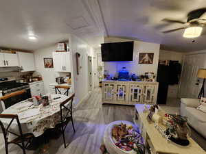 Living area featuring lofted ceiling, light wood-type flooring, and attic access