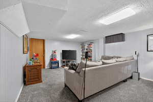 Carpeted basement living room with paneled walls and plush carpet