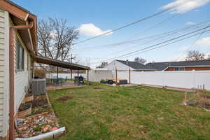 Fenced backyard featuring a covered patio area and shed