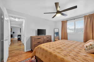 Primary bedroom featuring hardwood floors, a ceiling fan, and a closet