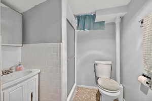 Basement bathroom with shower, tiled floors, and vanity