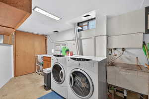 Laundry room with concrete flooring and washer and dryer