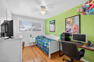 Bedroom with light hardwood flooring and ceiling fan