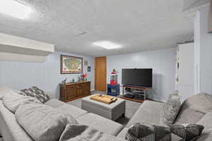 Carpeted basement living room with paneled walls and plush carpet