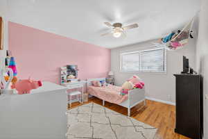 Bedroom with light hardwood flooring and ceiling fan