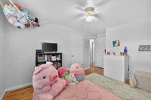 Bedroom with light hardwood flooring and ceiling fan