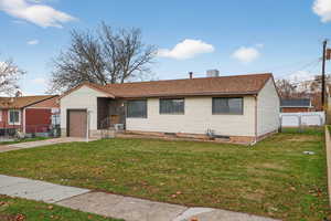 Ranch-style home featuring driveway, a shingled roof, a garage, and a fenced yard