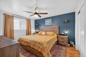 Primary bedroom featuring hardwood floors, a ceiling fan, and a closet