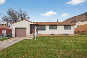 Single story home with concrete driveway, a shingled roof, and a mountain view