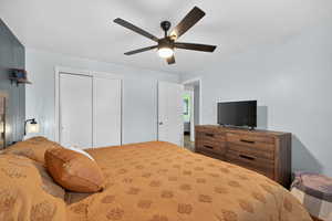 Primary bedroom featuring hardwood floors, a ceiling fan, and a closet