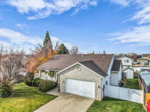 View of front of home featuring roof with shingles, brick siding, a garage, and driveway