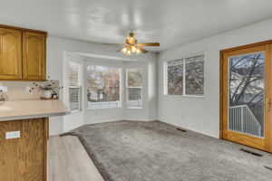 Unfurnished dining area featuring a ceiling fan and light carpet