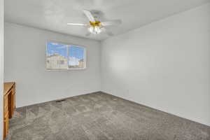 Empty room with light colored carpet and ceiling fan